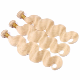  Three bundles of blonde machine weft hair extensions in body wave texture.